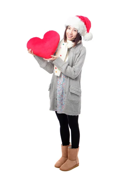 Girl in Santa hat holding heart pillow — Stock Photo, Image