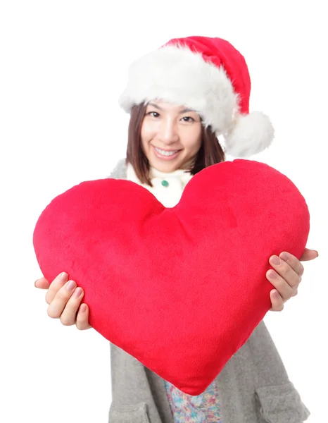 Menina bonita em chapéu de Santa segurando grande amor coração forma travesseiro isolado no fundo branco, beleza asiática — Fotografia de Stock