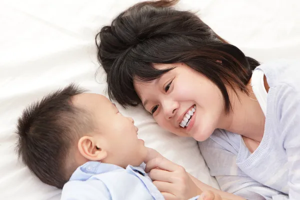 Mãe e filho sorriem e olham um para o outro — Fotografia de Stock