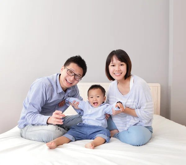 Família feliz jogar na cama — Fotografia de Stock