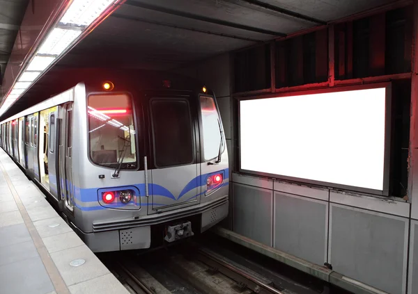 Träna på tunnelbanestation med skylt — Stockfoto