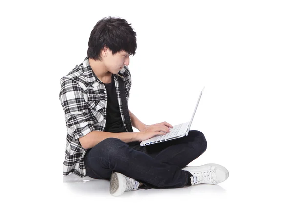 Young man sitting on the floor with laptop — Stock Photo, Image