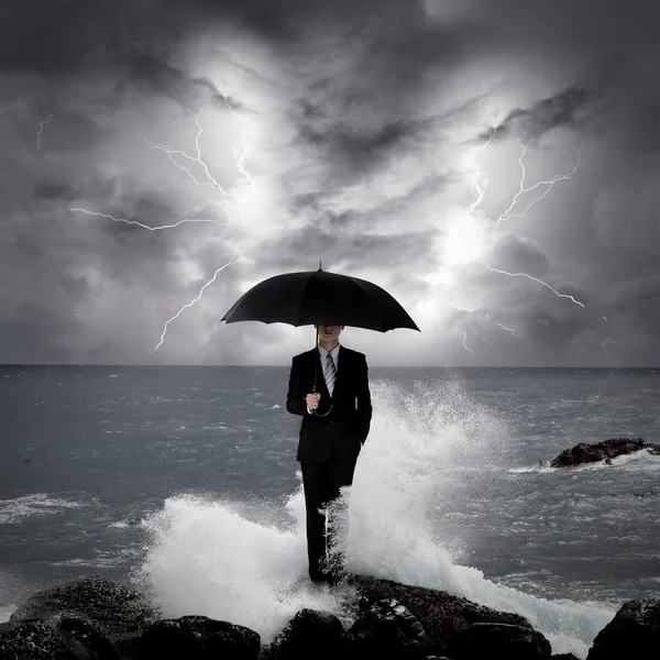 Business man under an umbrella in the sea — Stock Photo, Image