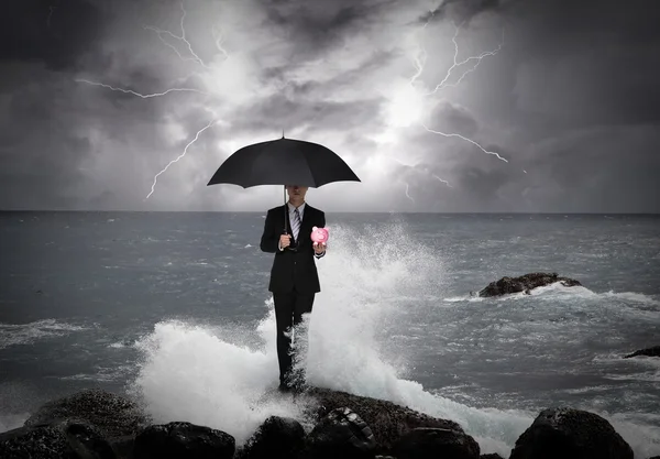 Business man under an umbrella in the sea — Stock Photo, Image