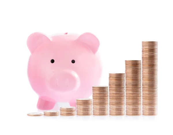 Roze piggy bank en stapels van geld munten — Stockfoto