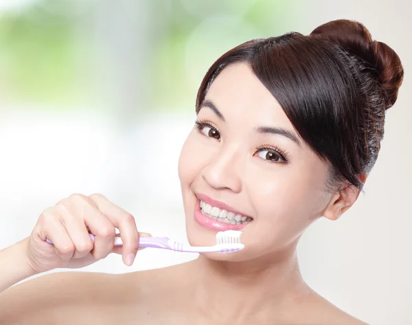 Usmívající se žena čištění zubů s kartáček — Stock fotografie