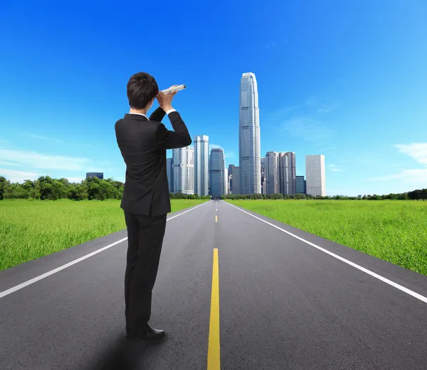 Businessman with telescope looking forward — Stock Photo, Image