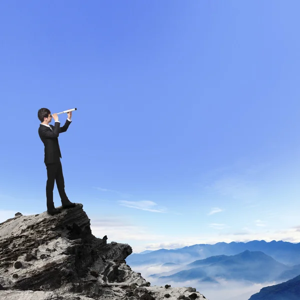 Obchodní muž vypadá dalekohledem na hoře — Stock fotografie