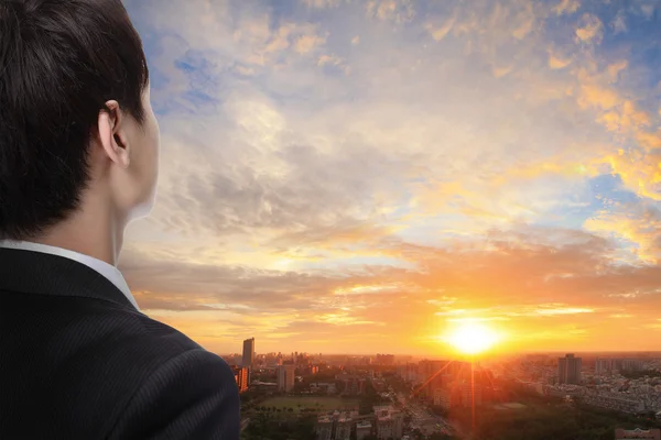 Homme d'affaires regarder lever de soleil dans la ville — Photo