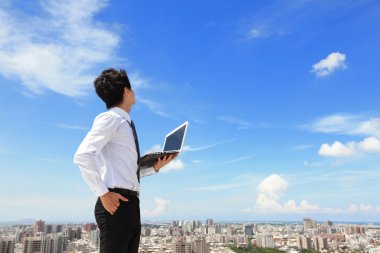Business man with laptop and look sky and cloud clipart