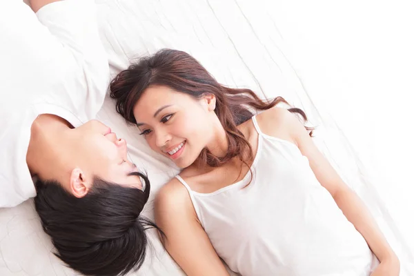 Casal sorriso feliz olhando um para o outro na cama — Fotografia de Stock