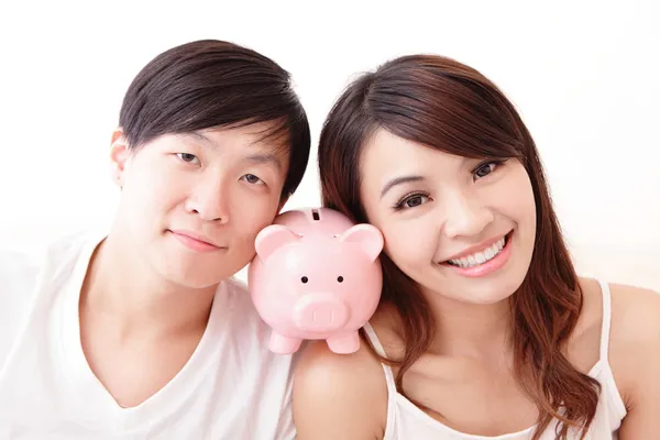 Happy couple with pink piggy bank — Stock Photo, Image
