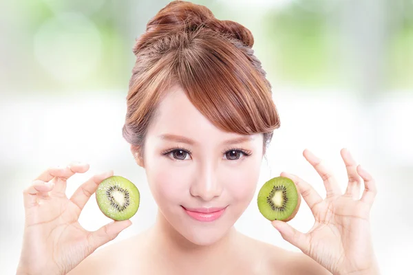 Mujer sosteniendo kiwi fruta cubrir sus ojos —  Fotos de Stock