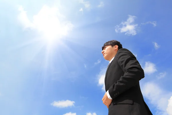 Business man standing over blue sky — Stock Photo, Image