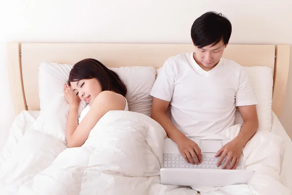 Veselý pár pomocí dotykové podložky v posteli — Stock fotografie