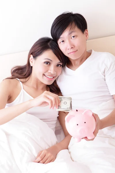 Casal feliz com o banco piggy rosa — Fotografia de Stock