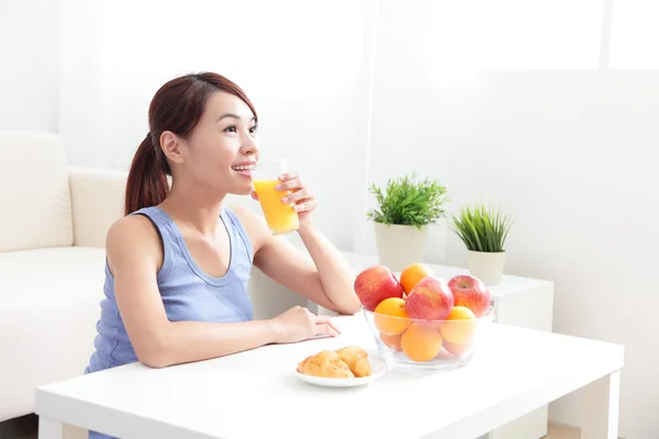 Mulher alegre bebendo um suco de laranja — Fotografia de Stock