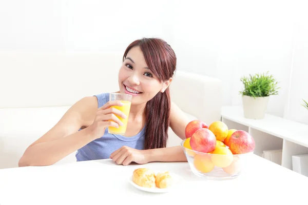 Fröhliche Frau trinkt einen Orangensaft — Stockfoto