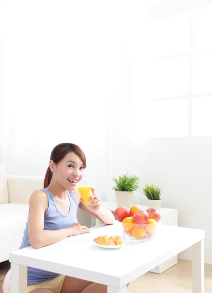 Veselá žena pít pomerančový džus — Stock fotografie