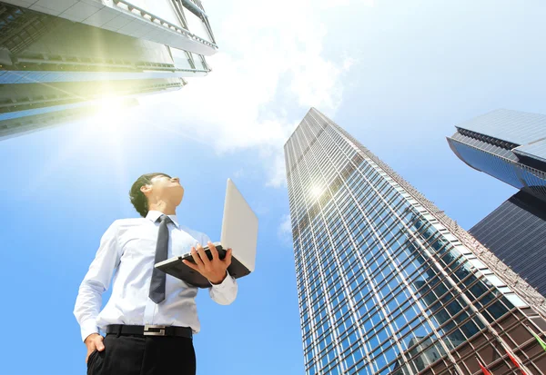 Forretningsmann med bærbar PC og se himmel og sky ut – stockfoto