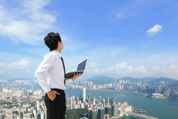 Geschäftsmann mit Laptop und Blick in die Stadt — Stockfoto