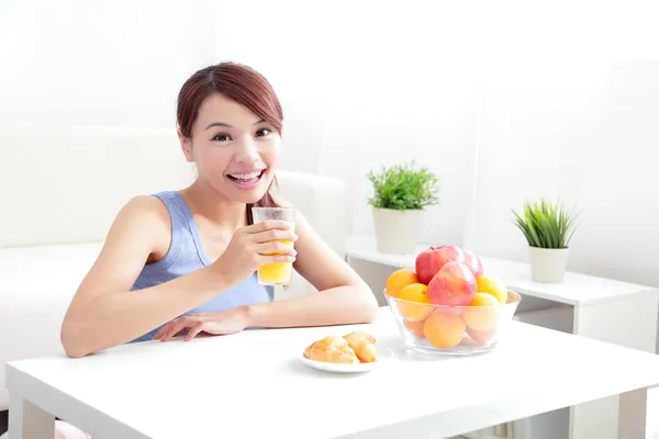 Fröhliche Frau trinkt einen Orangensaft — Stockfoto