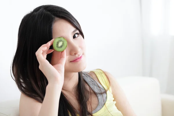 Mulher com fatias de kiwi na frente dos olhos — Fotografia de Stock