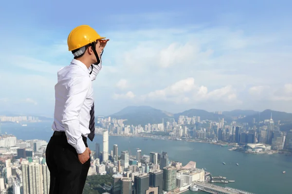 Arquiteto com capacete procurando edifício da cidade — Fotografia de Stock