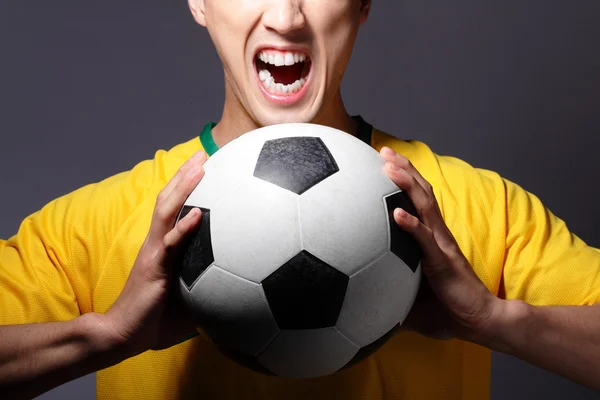 Emocionado hombre del deporte gritando y sosteniendo la pelota de fútbol —  Fotos de Stock