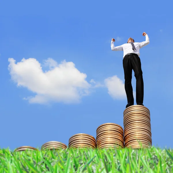 Businessman standing on coins — Stock Photo, Image