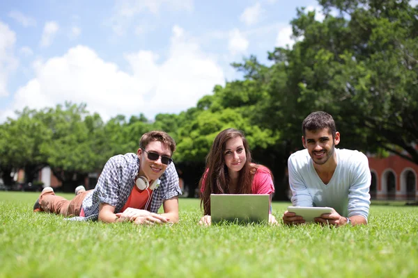 Счастливые студенты колледжей с помощью компьютера — стоковое фото