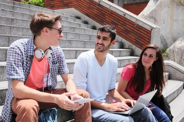 Glada studenter med digital tablet — Stockfoto