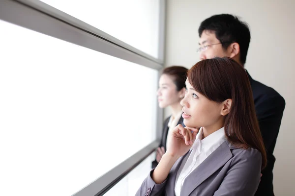 Business team guardando attraverso la finestra — Foto Stock
