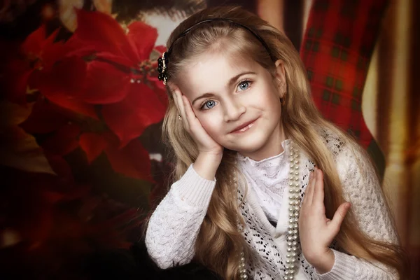 Beautiful little girl holding her hands near the face on christmas style background — Stock Photo, Image