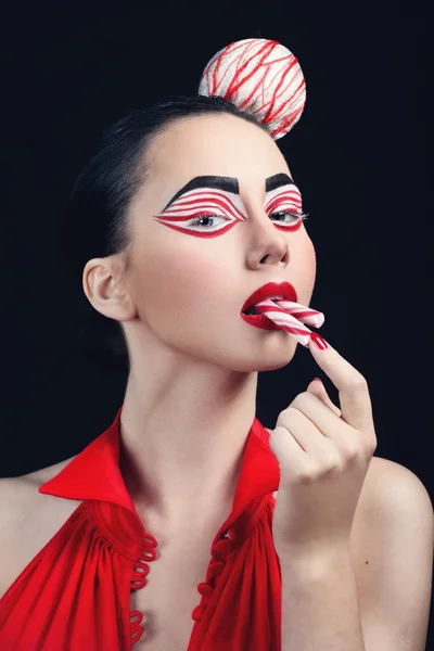 Приваблива брюнетка з цукерками стиль макіяж їсть цукерки Ліцензійні Стокові Зображення
