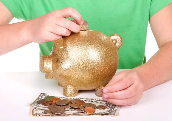 Criança colocando dinheiro no banco porquinho — Fotografia de Stock