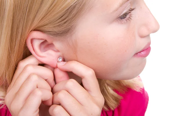 Teen putting in ear ring — Stock Photo, Image
