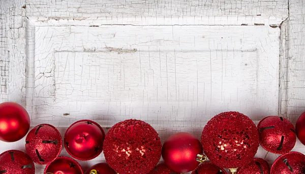 Red Christmas ornaments on wood panel — Stock Photo, Image