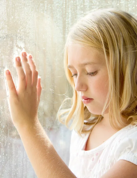Barn eller en tonåring på ett fönster — Stockfoto