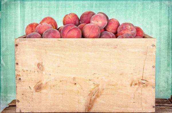 Many peaches in wooden crate — Stock Photo, Image