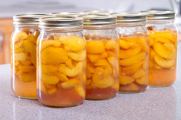 Row of canned peaches — Stock Photo, Image