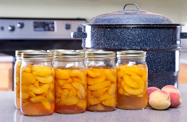 Canned peaches with large pot or canner — Stock Photo, Image