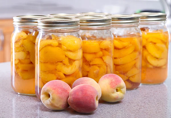 Row of canned peaches — Stock Photo, Image