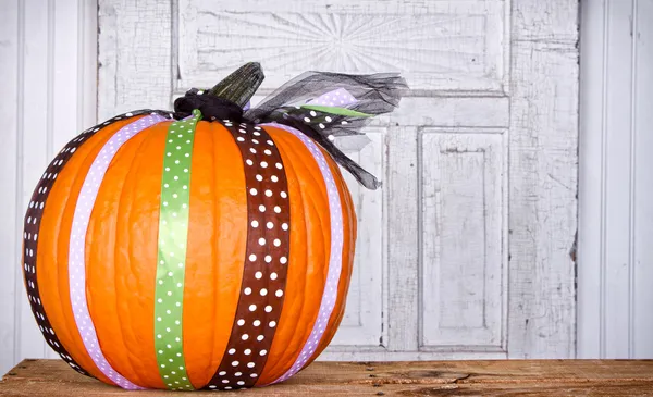 A pumpkin decorated with ribbon — Stock Photo, Image