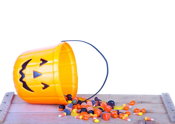 Halloween candy and pumpkin bucket on wood — Stock Photo, Image