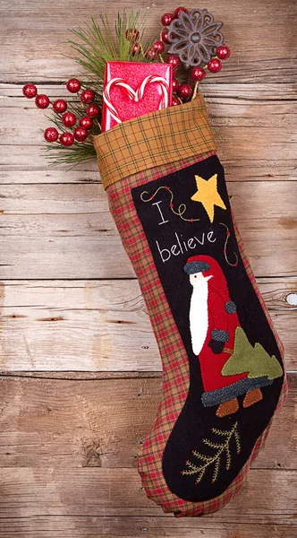 Christmas stocking with presents on wood — Stock Photo, Image