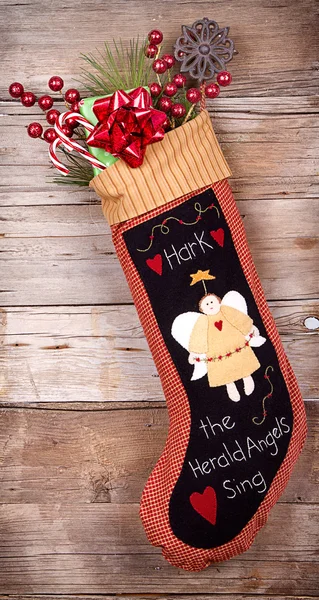 Christmas stocking with presents on wood — Stock Photo, Image