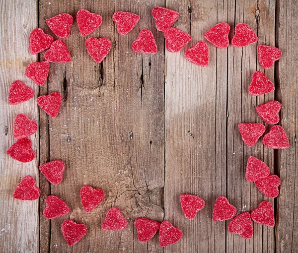 Heart shape candy on wooden plank — Stock Photo, Image