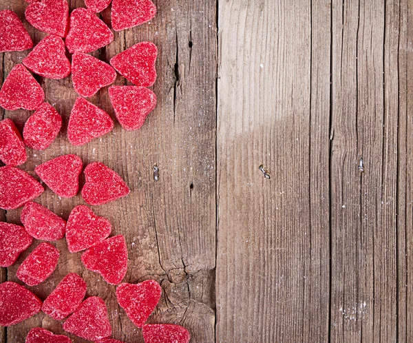 Bonbons en forme de coeur sur planche de bois — Photo