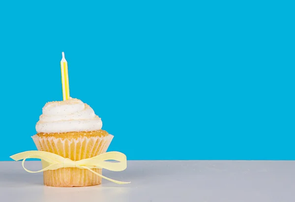 Single Cupcake mit gelber Kerze — Stockfoto